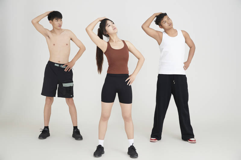 两名年轻男子在美女教练的带领下做健身操图片