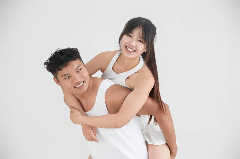 白色背景下嬉戏欢乐的亚洲情侣图片