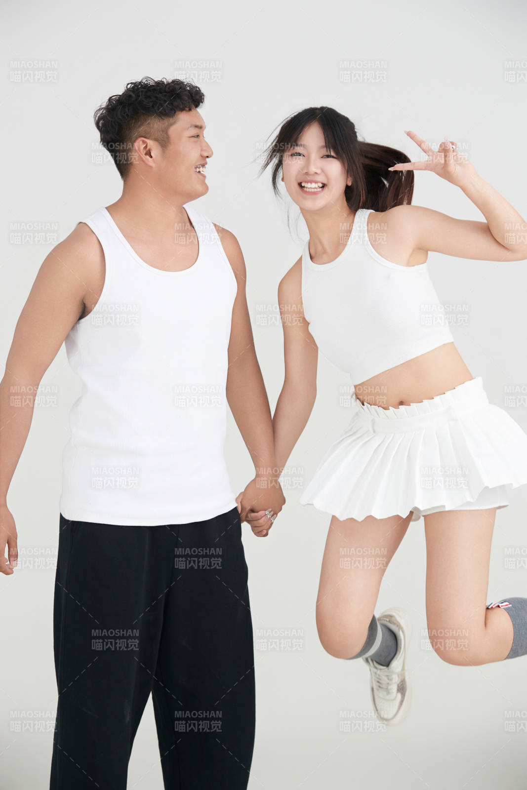 白色背景下嬉戏欢乐的亚洲情侣图片