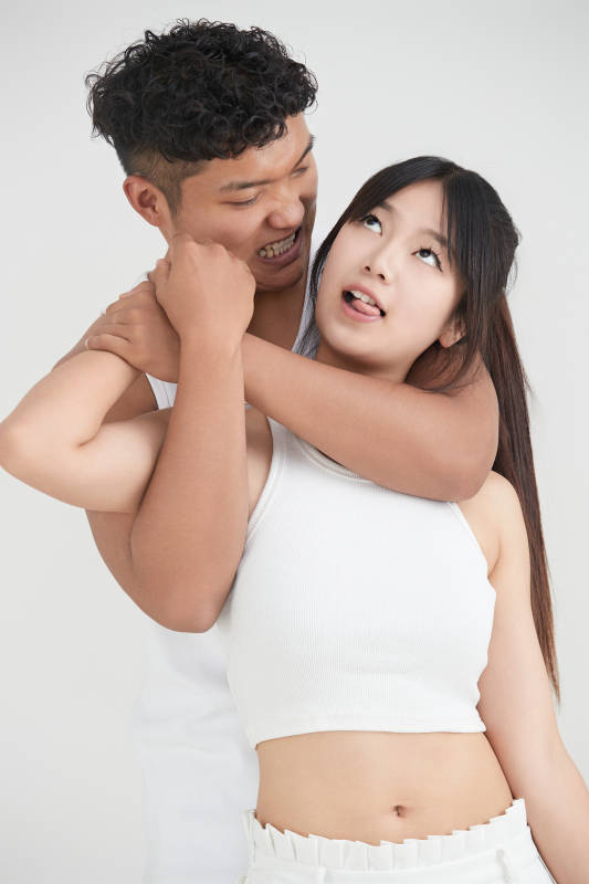 白色背景下嬉戏欢乐的亚洲情侣图片