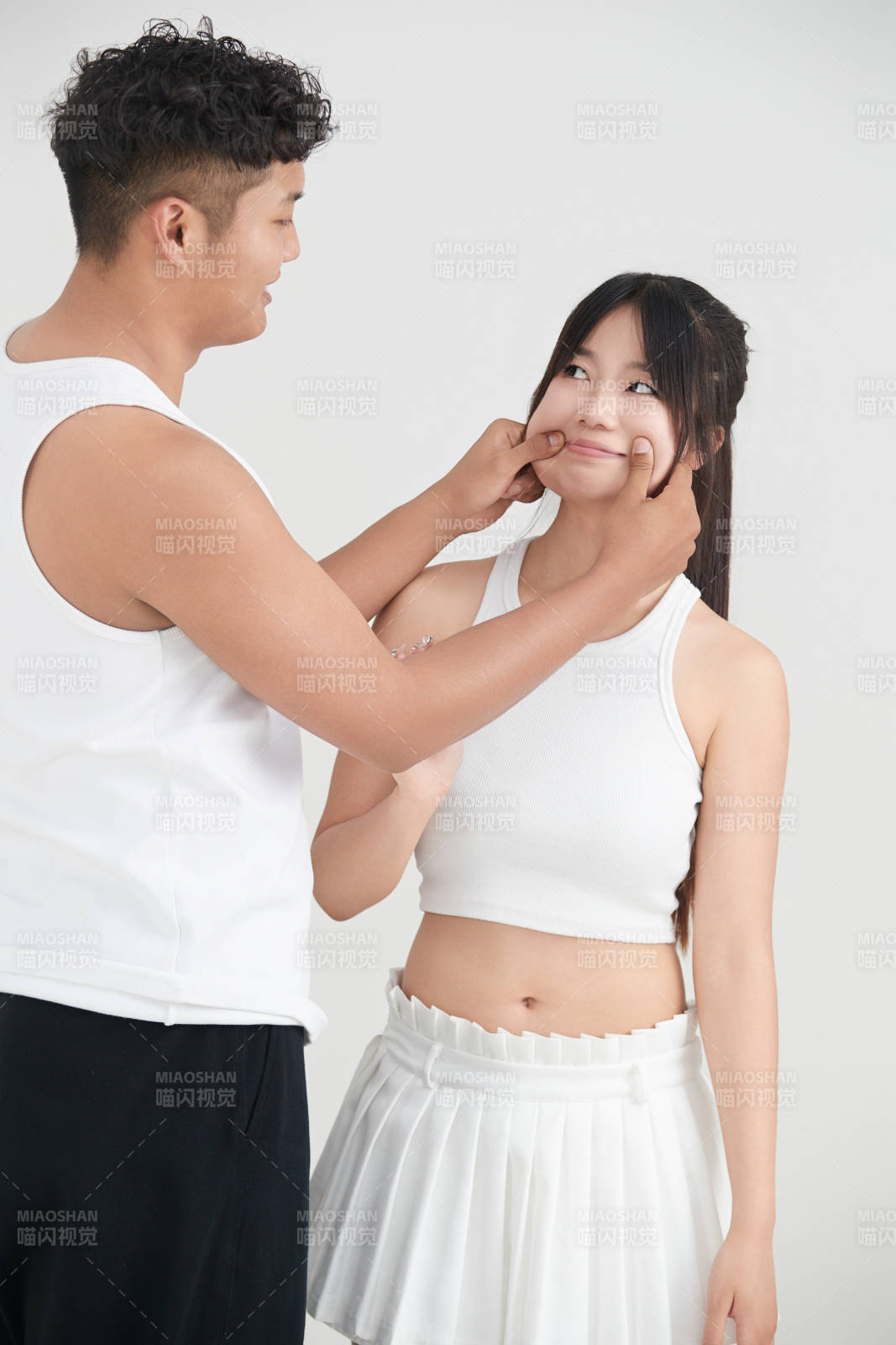 白色背景下嬉戏欢乐的亚洲情侣图片