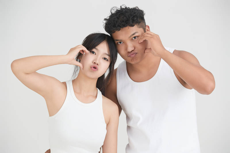 白色背景下嬉戏欢乐的亚洲情侣图片