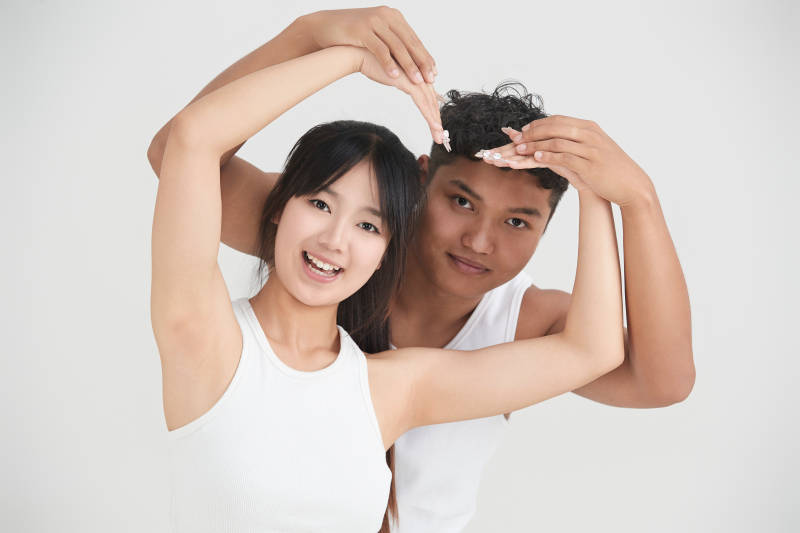 白色背景下嬉戏欢乐的亚洲情侣图片