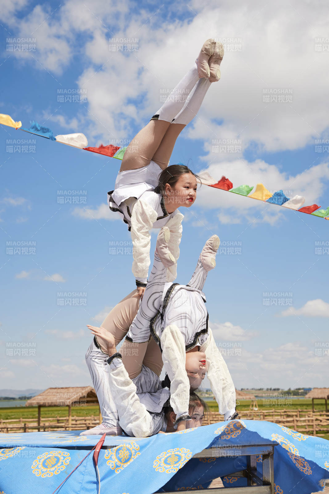 进行柔术体操杂技表演的三个少女图片