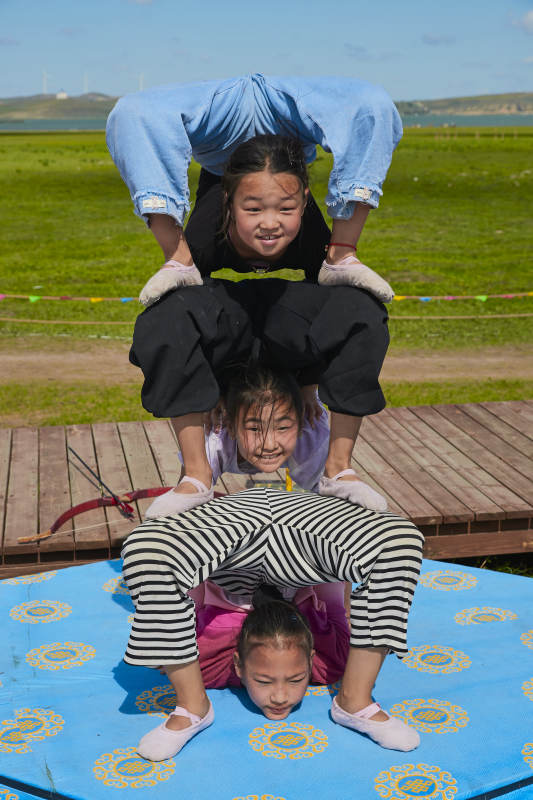 进行柔术体操杂技表演的三个少女图片