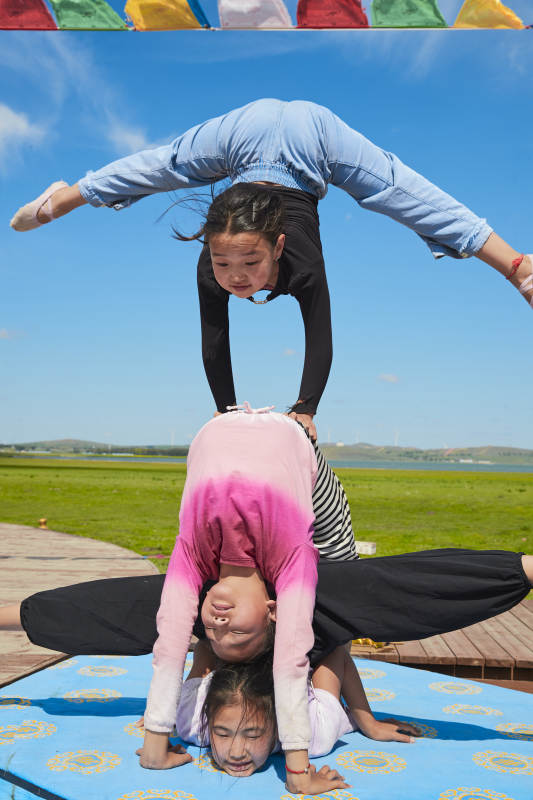 进行柔术体操杂技表演的三个少女图片