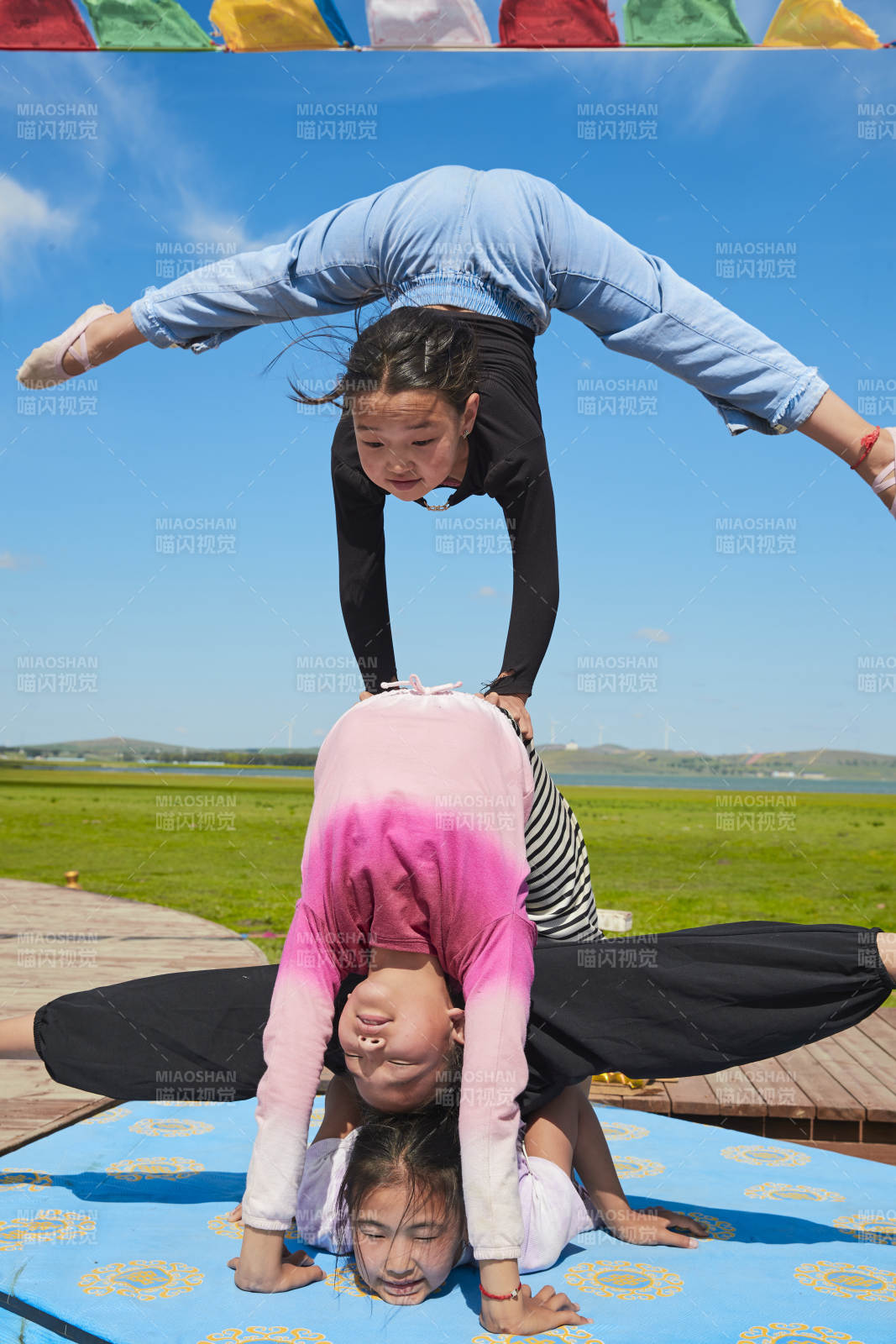 进行柔术体操杂技表演的三个少女图片