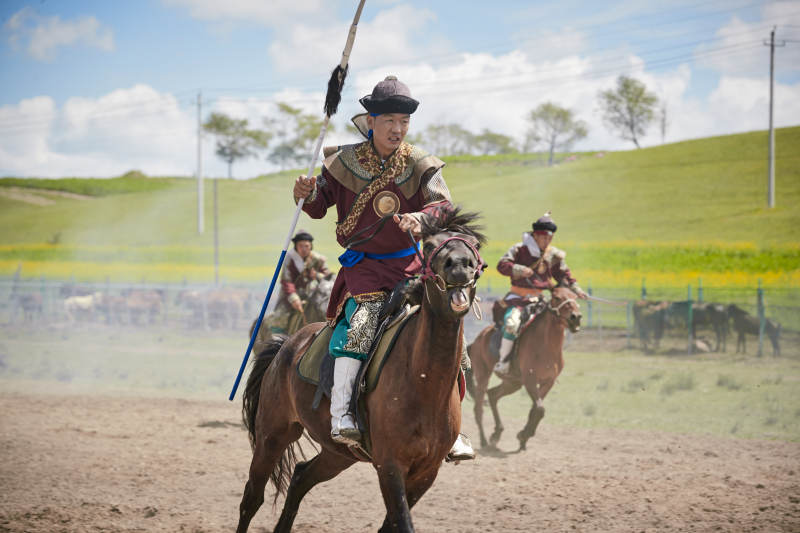 在草原景区表演的蒙古古代骑马打仗演出图片