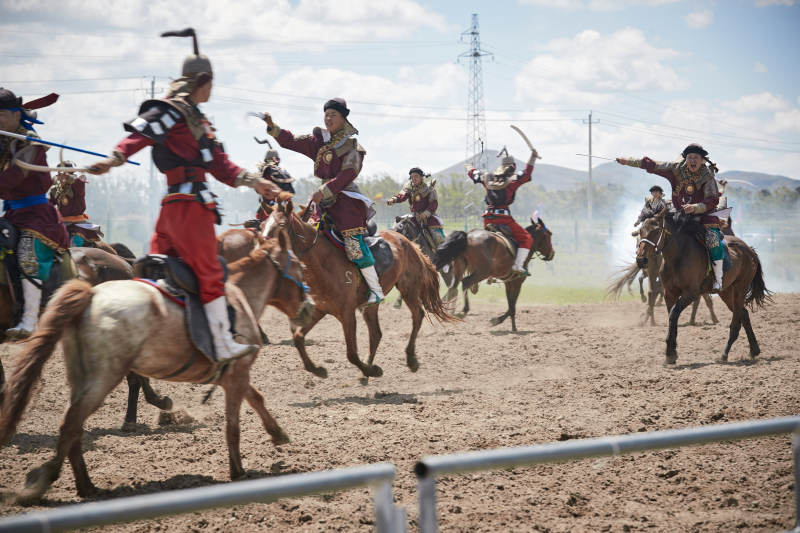 在草原景区表演的蒙古古代骑马打仗演出图片