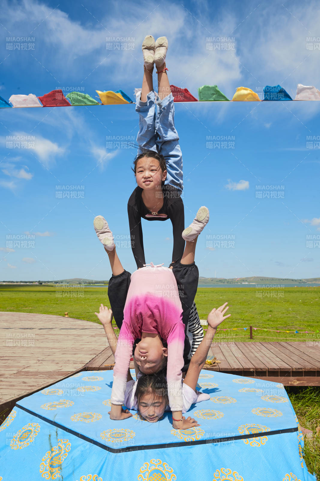 进行柔术体操杂技表演的三个少女图片