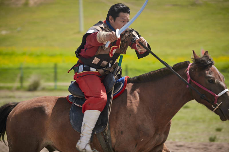在草原景区表演的蒙古古代骑马打仗演出图片