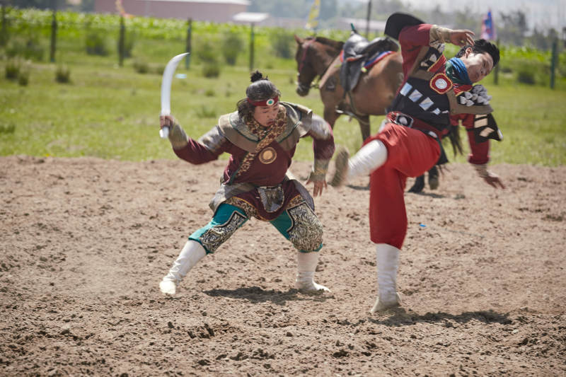 在草原景区表演的蒙古古代骑马打仗演出图片