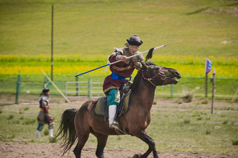 在草原景区表演的蒙古古代骑马打仗演出图片