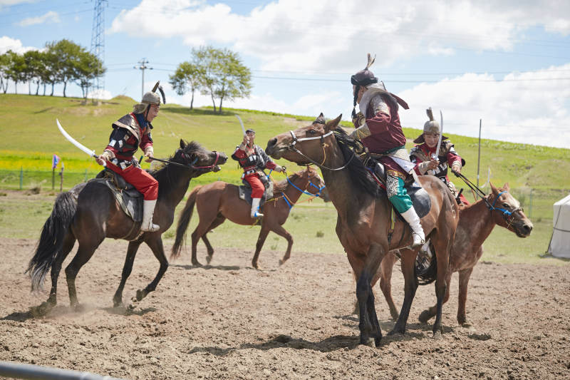 在草原景区表演的蒙古古代骑马打仗演出图片