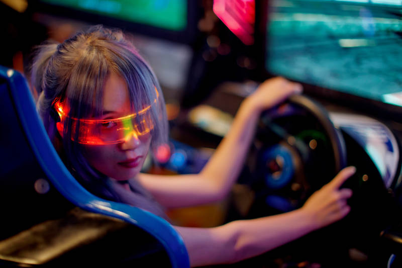 在电子游戏娱乐城玩耍的亚洲时尚少女图片