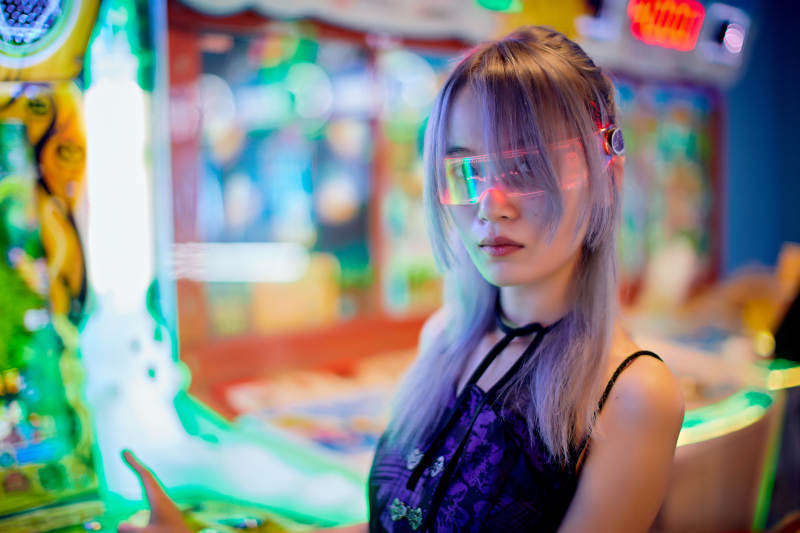 在电子游戏娱乐城玩耍的亚洲时尚少女图片