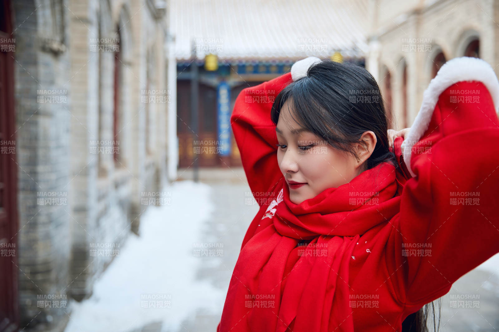 雪后在老城古巷穿着喜庆服饰的亚洲少女图片