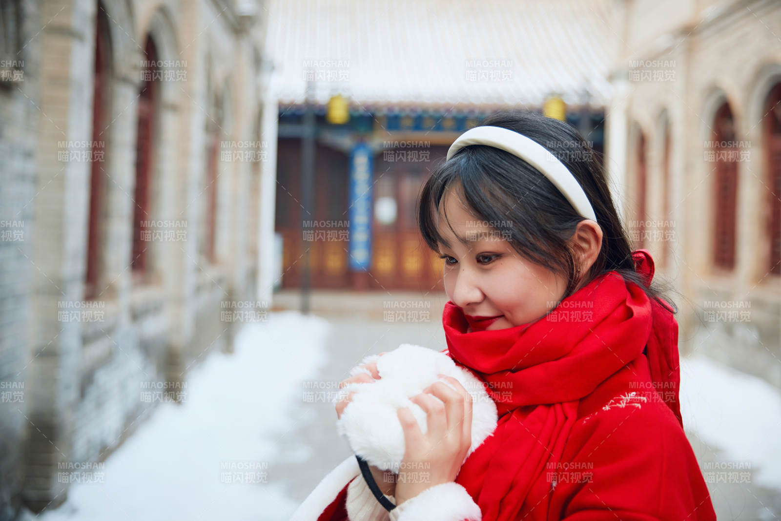 雪后在老城古巷穿着喜庆服饰的亚洲少女图片