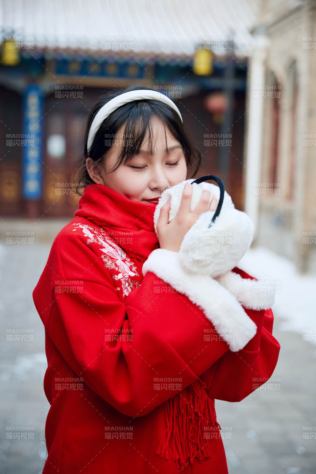 雪后在老城古巷穿着喜庆服饰的亚洲少女图片