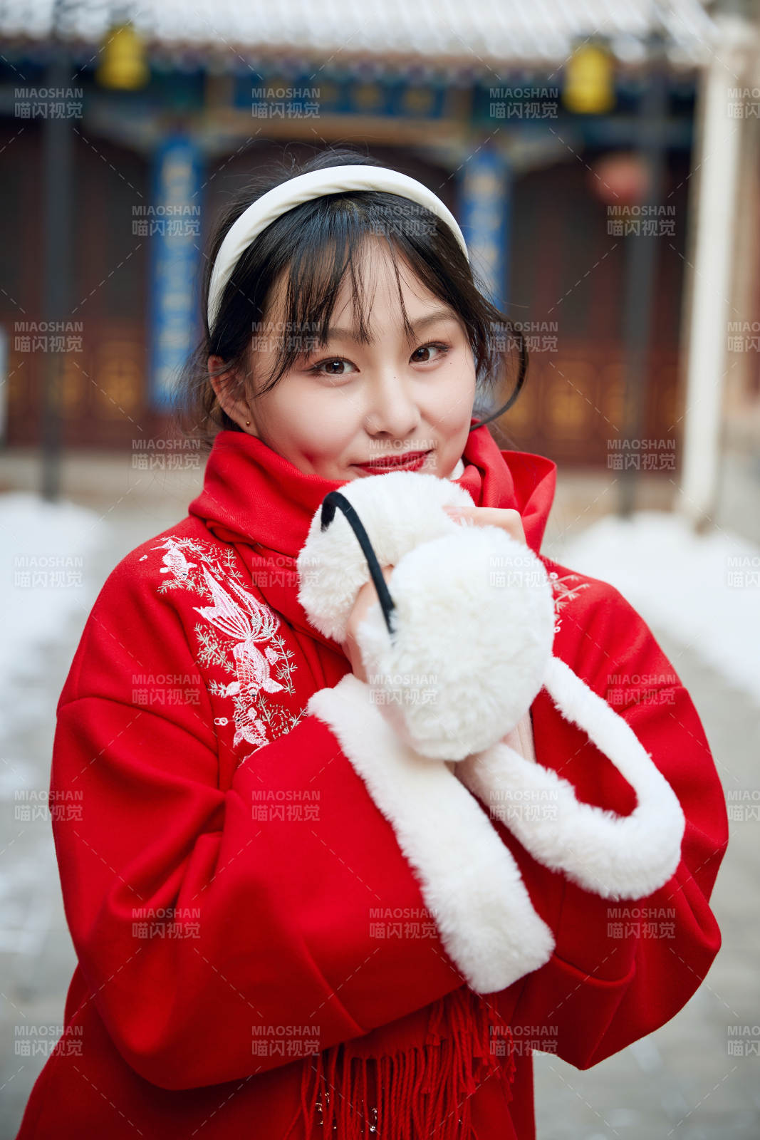 雪后在老城古巷穿着喜庆服饰的亚洲少女图片