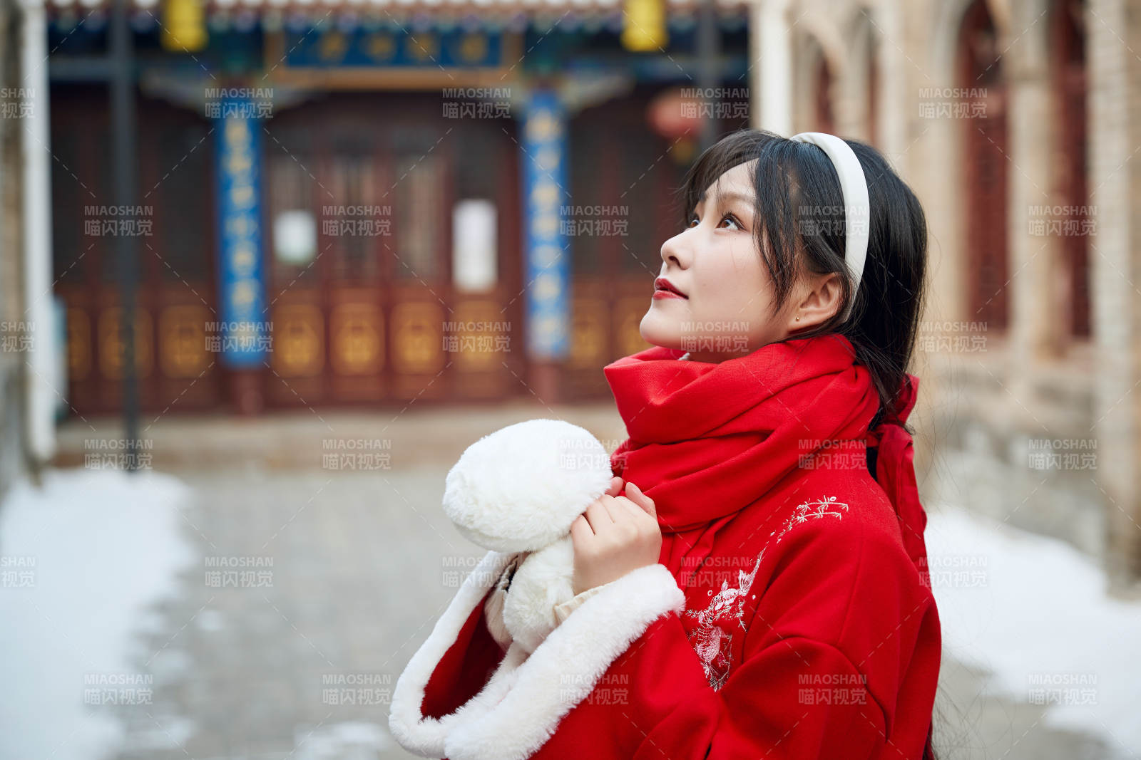 雪后在老城古巷穿着喜庆服饰的亚洲少女图片