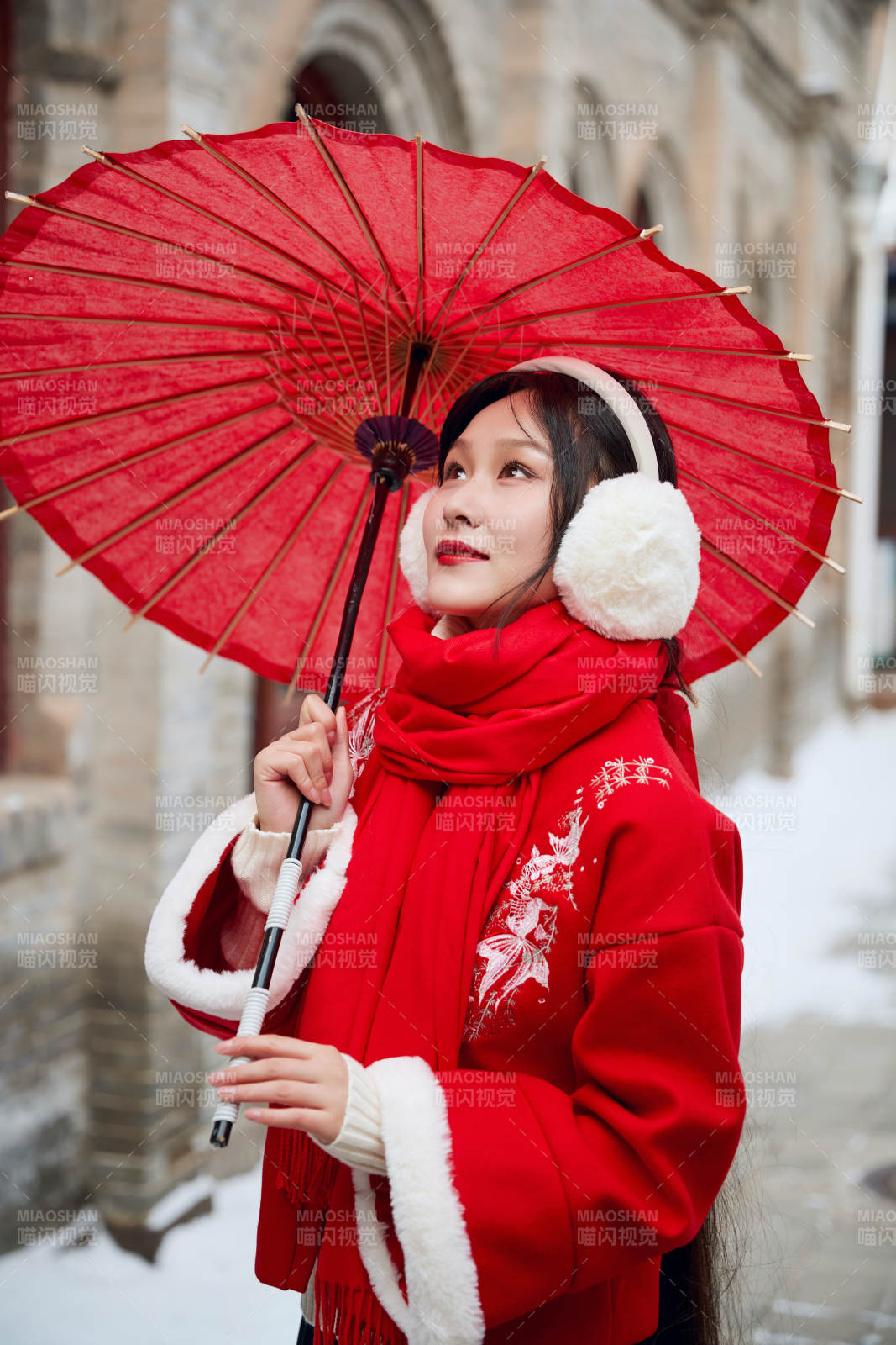 雪后在老城古巷穿着喜庆服饰的亚洲少女图片
