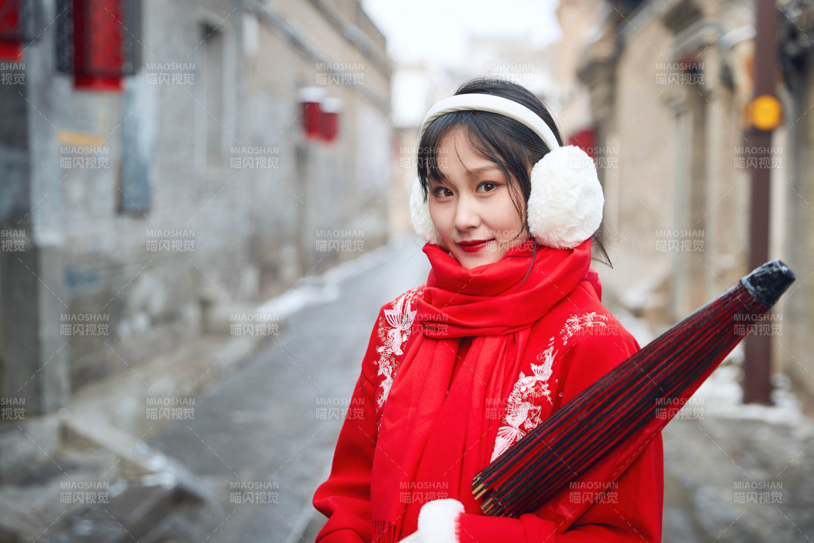 雪后在老城古巷穿着喜庆服饰的亚洲少女图片