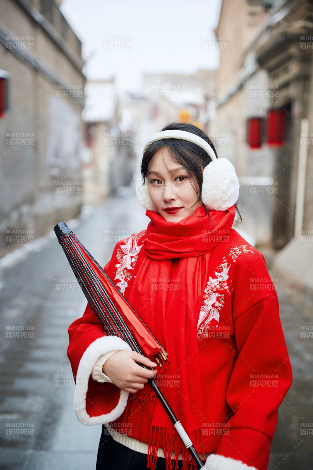 雪后在老城古巷穿着喜庆服饰的亚洲少女图片