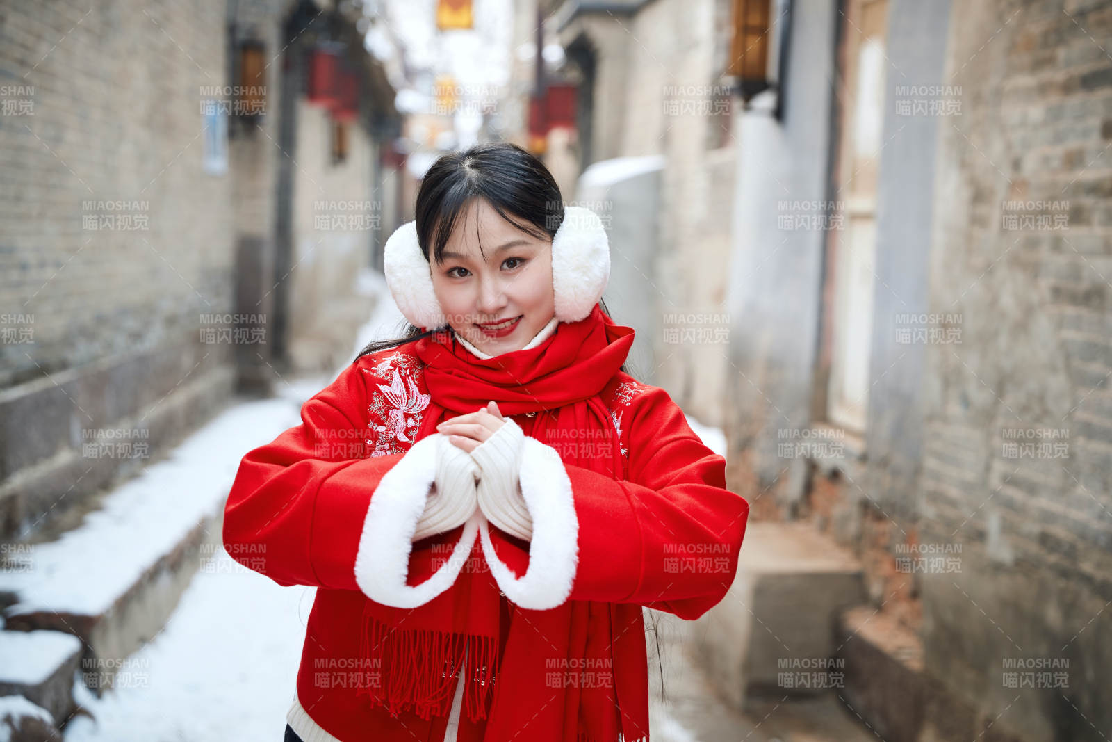 雪后在老城古巷穿着喜庆服饰的亚洲少女图片
