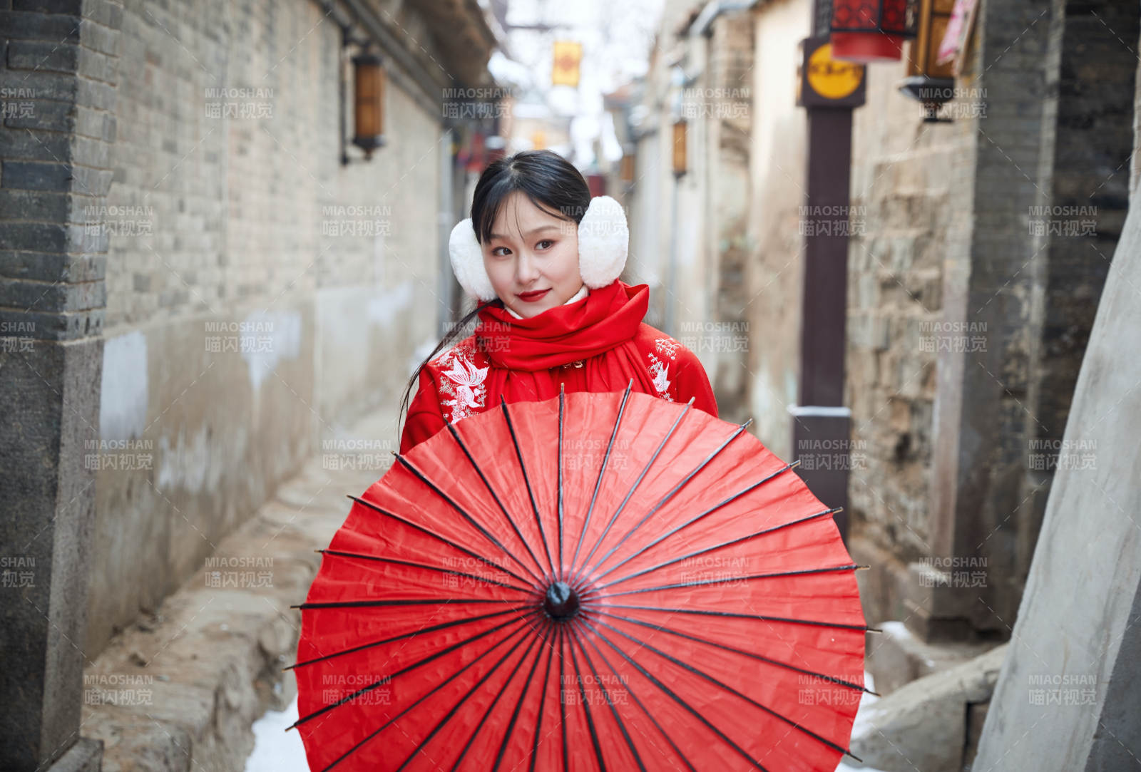 雪后在老城古巷穿着喜庆服饰的亚洲少女图片