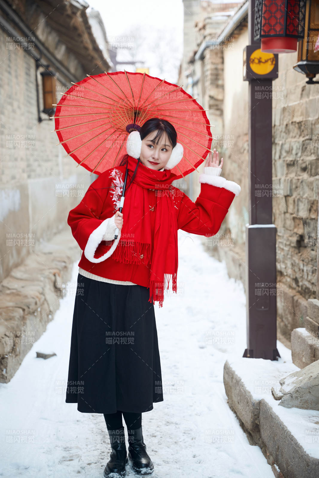 雪后在老城古巷穿着喜庆服饰的亚洲少女图片