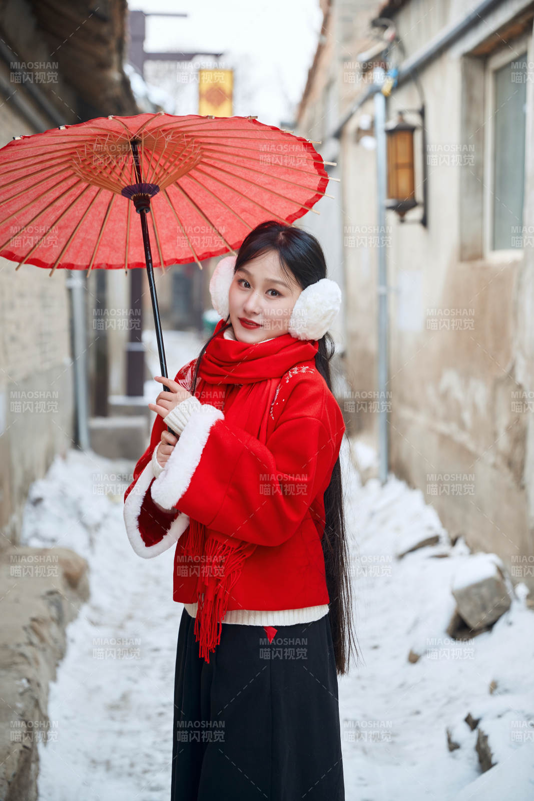 雪后在老城古巷穿着喜庆服饰的亚洲少女图片