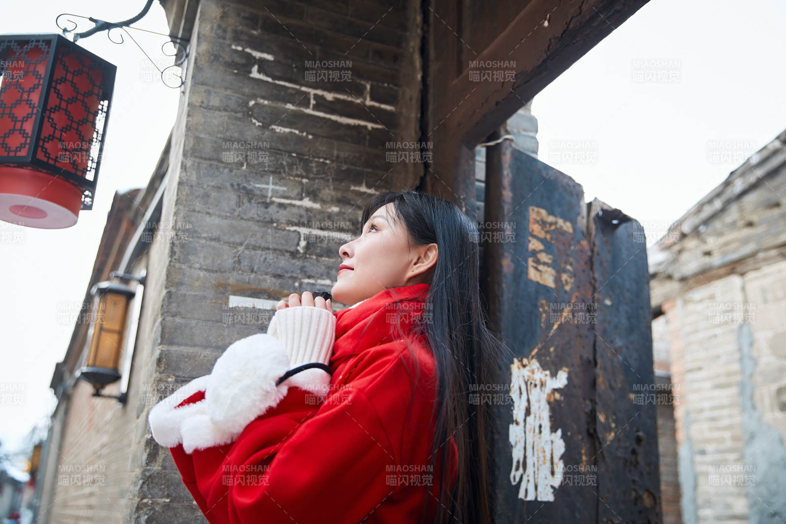 雪后在老城古巷穿着喜庆服饰的亚洲少女图片