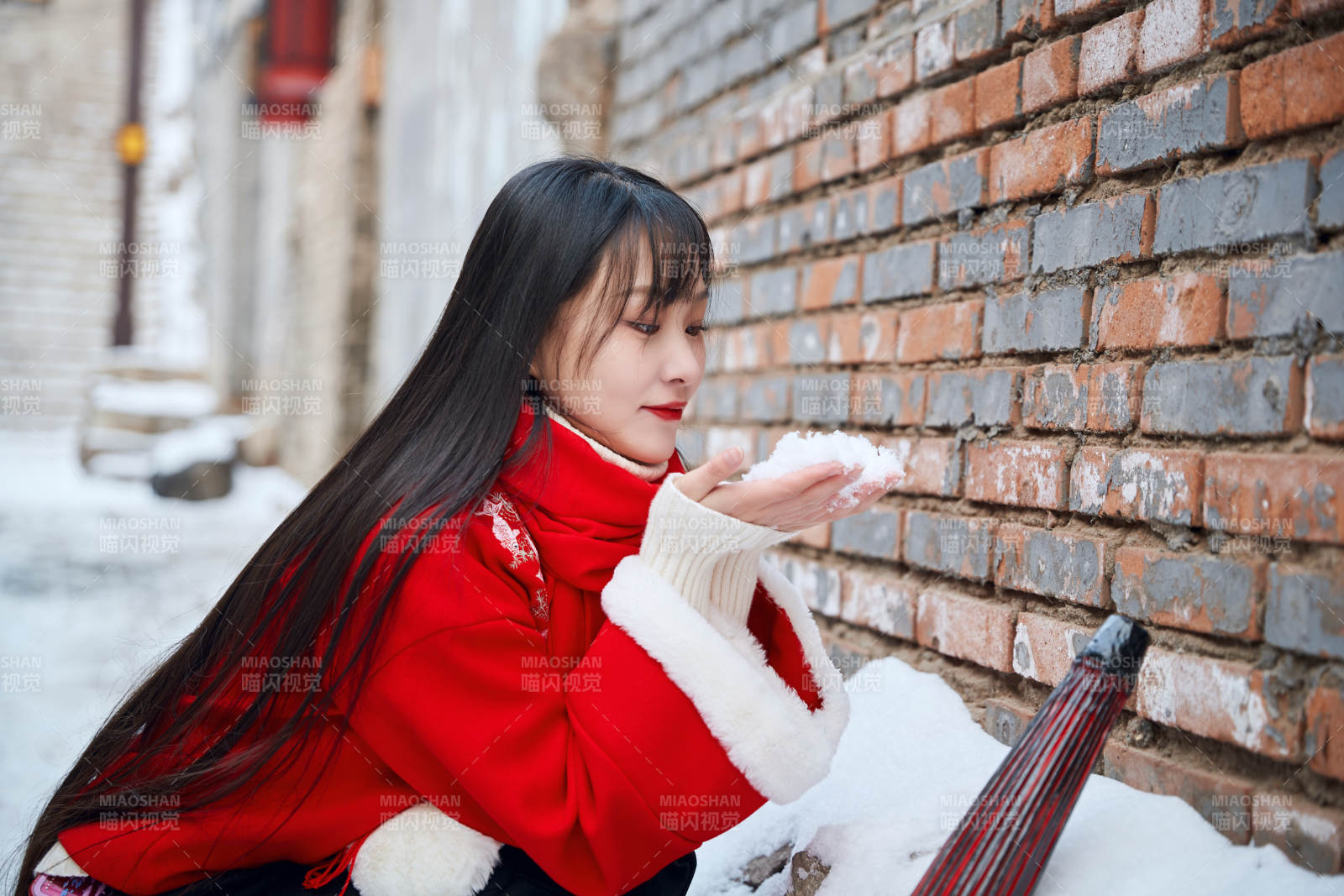 雪后在老城古巷穿着喜庆服饰的亚洲少女图片