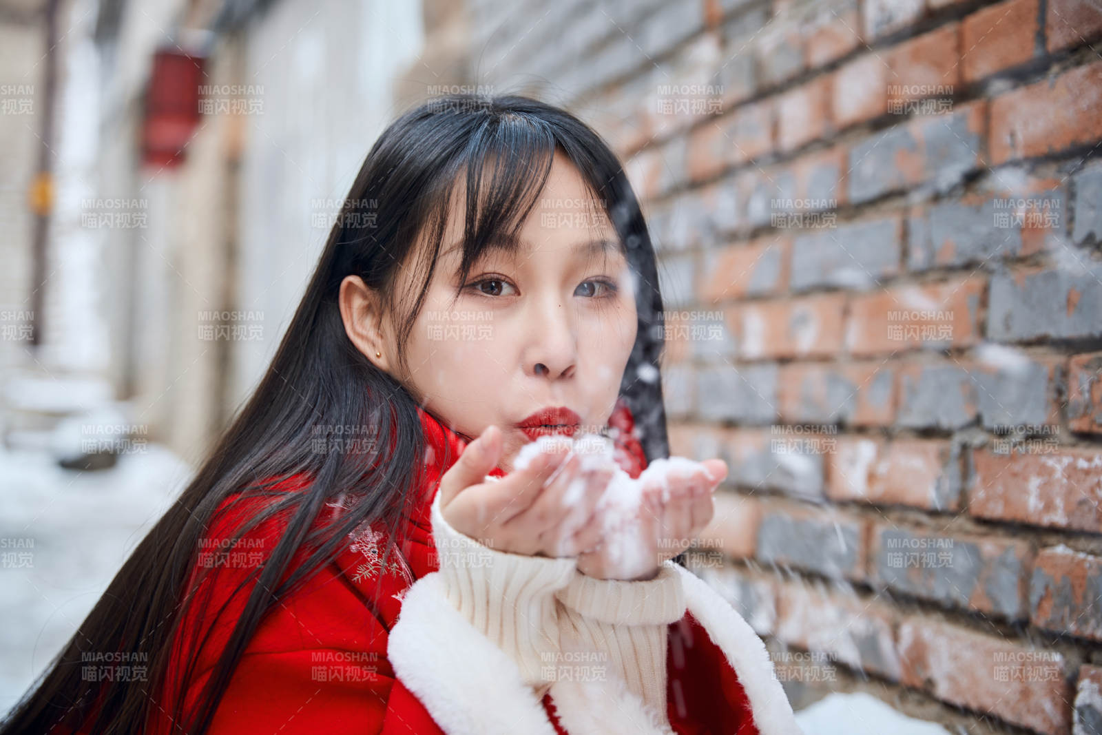 雪后在老城古巷穿着喜庆服饰的亚洲少女图片