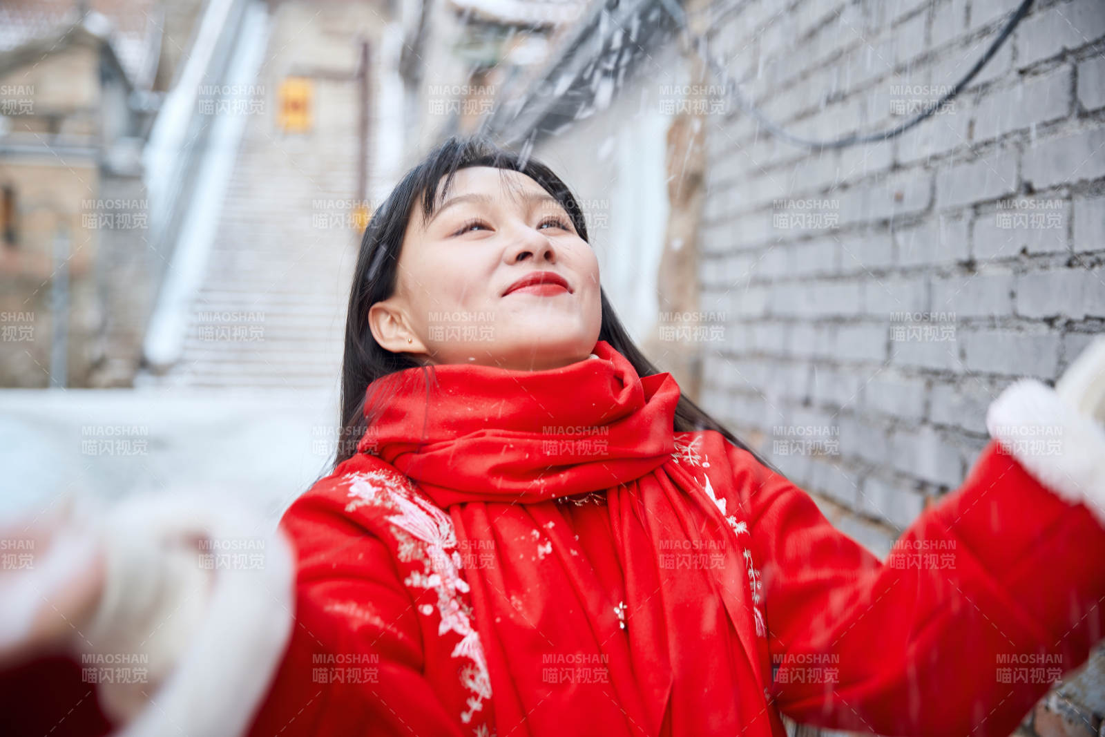 雪后在老城古巷穿着喜庆服饰的亚洲少女图片