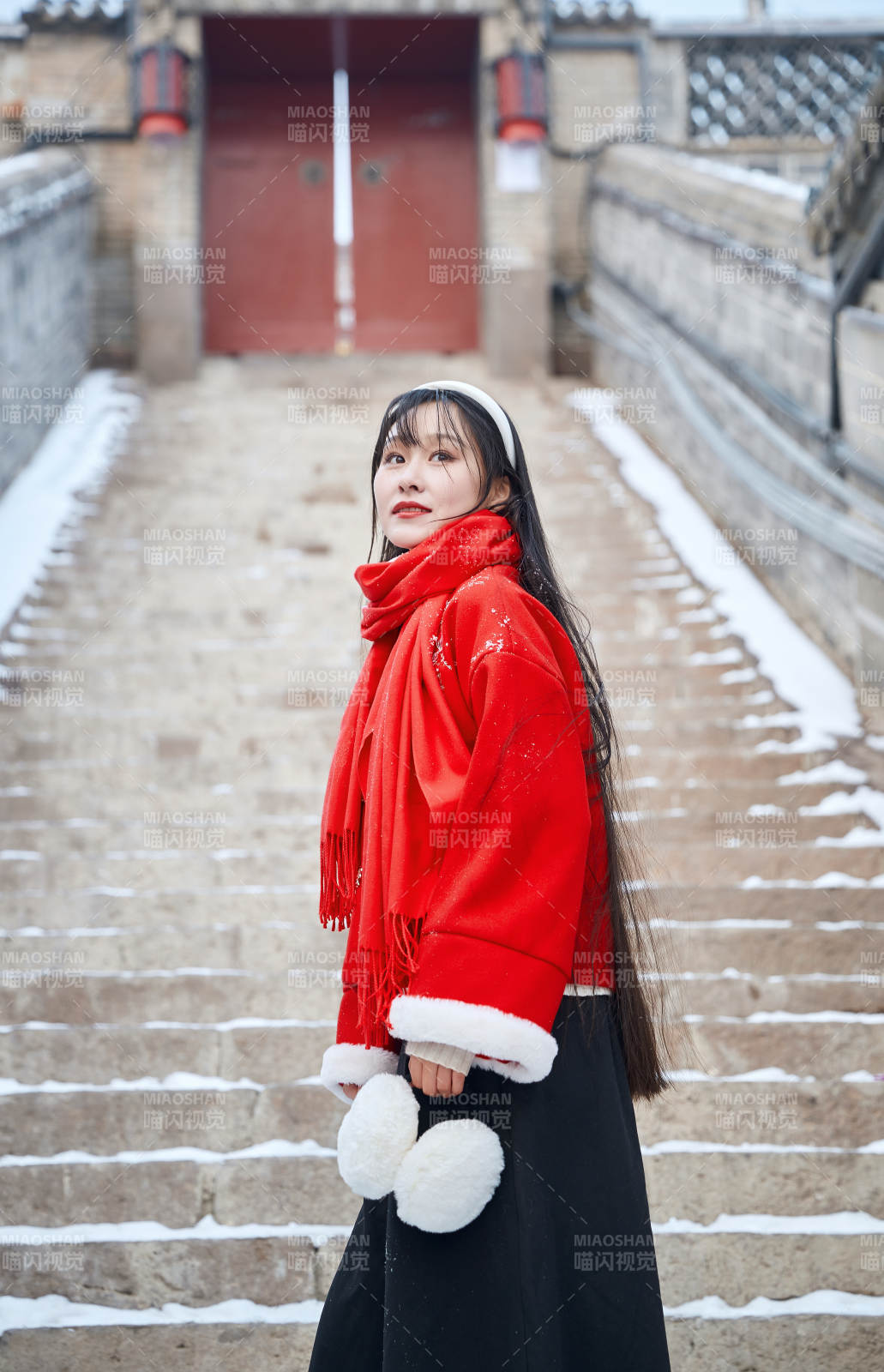 雪后在老城古巷穿着喜庆服饰的亚洲少女图片