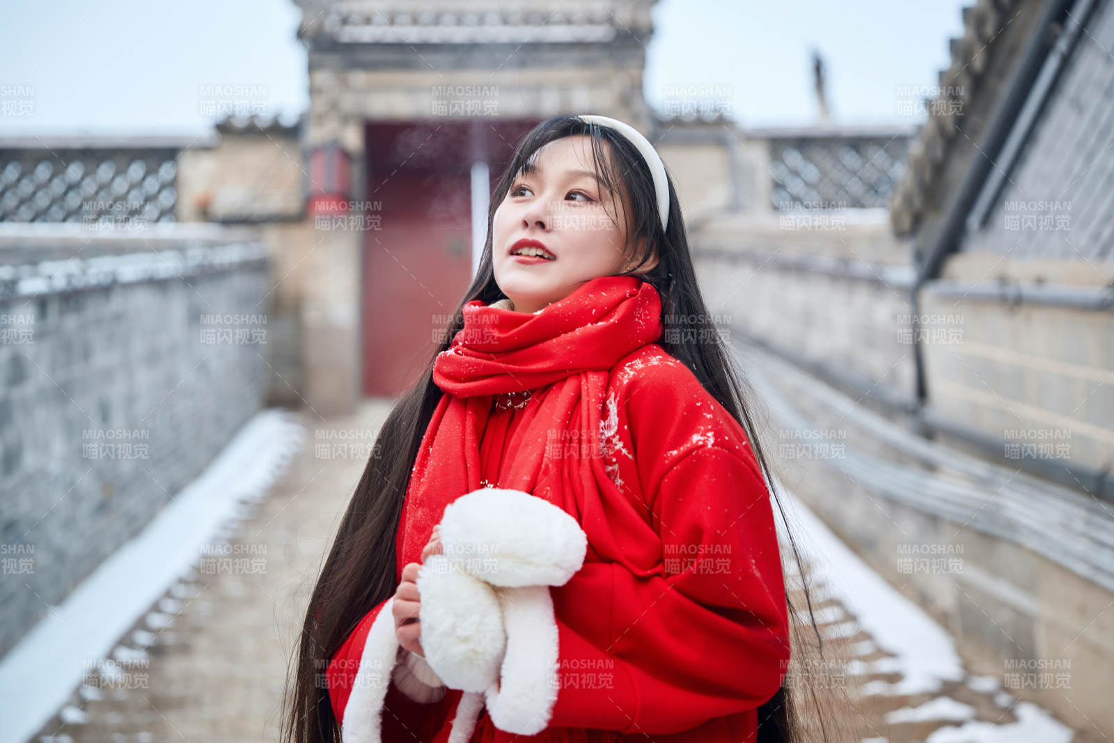 雪后在老城古巷穿着喜庆服饰的亚洲少女图片