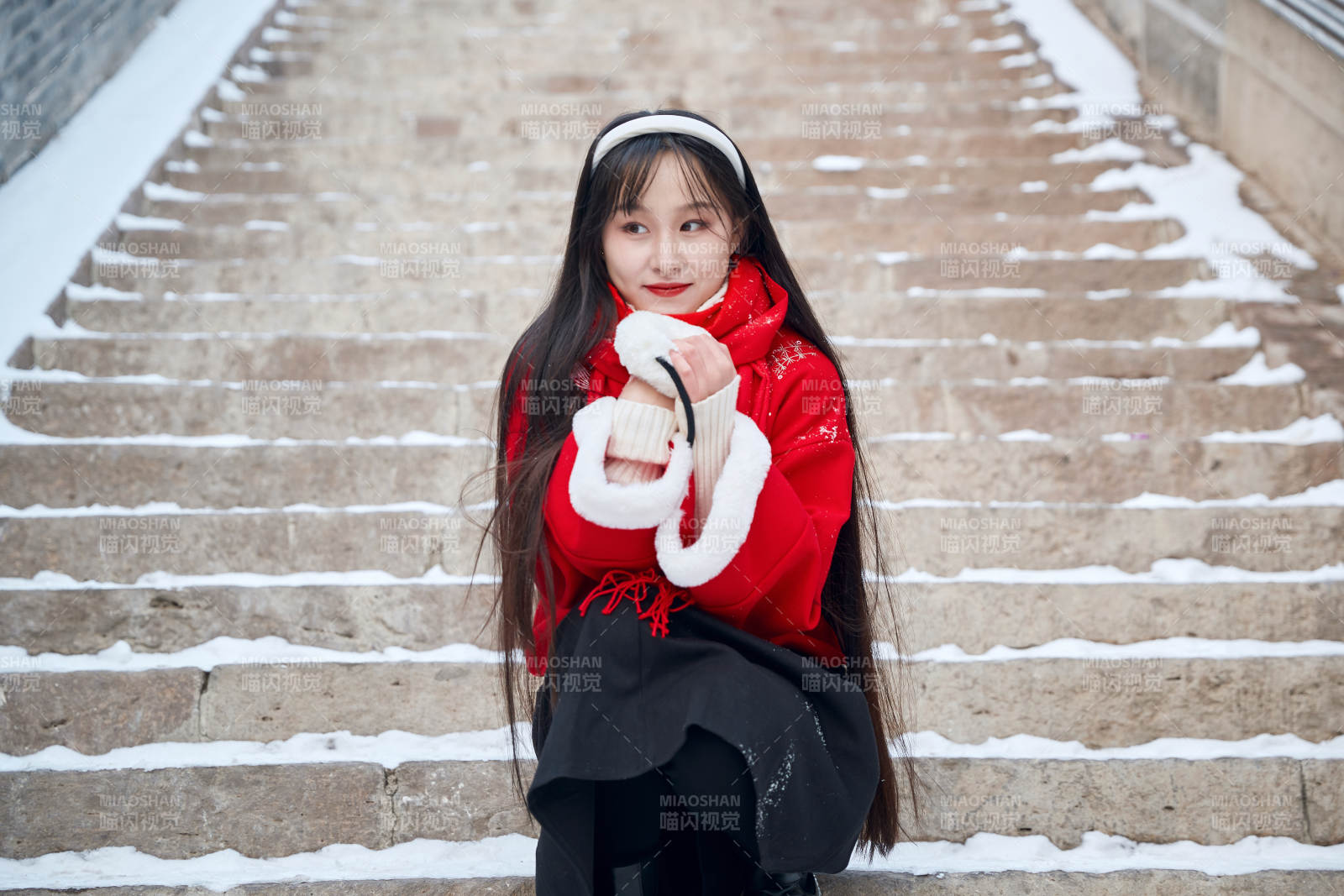 雪后在老城古巷穿着喜庆服饰的亚洲少女图片