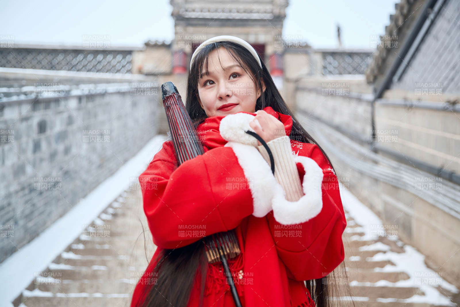 雪后在老城古巷穿着喜庆服饰的亚洲少女图片