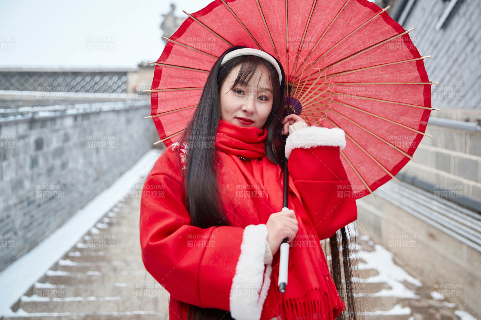 雪后在老城古巷穿着喜庆服饰的亚洲少女图片