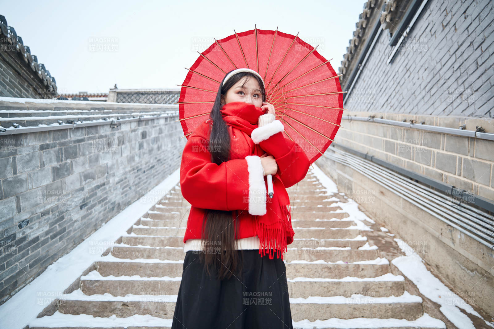 雪后在老城古巷穿着喜庆服饰的亚洲少女图片
