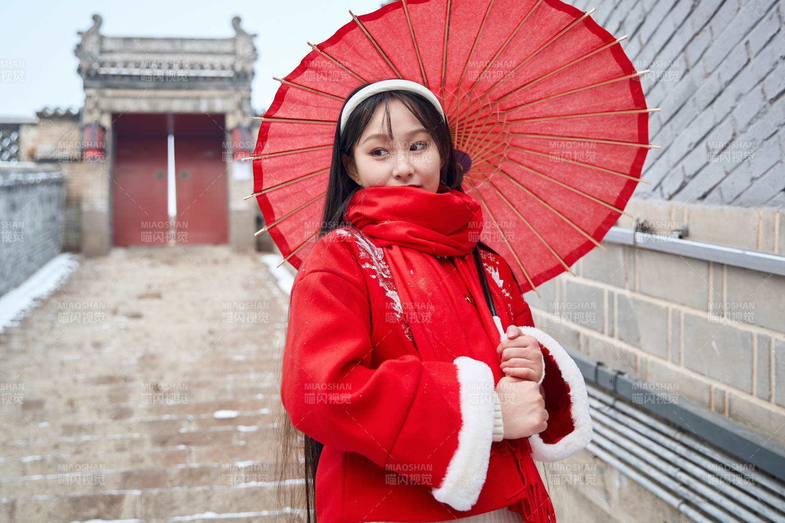 雪后在老城古巷穿着喜庆服饰的亚洲少女图片