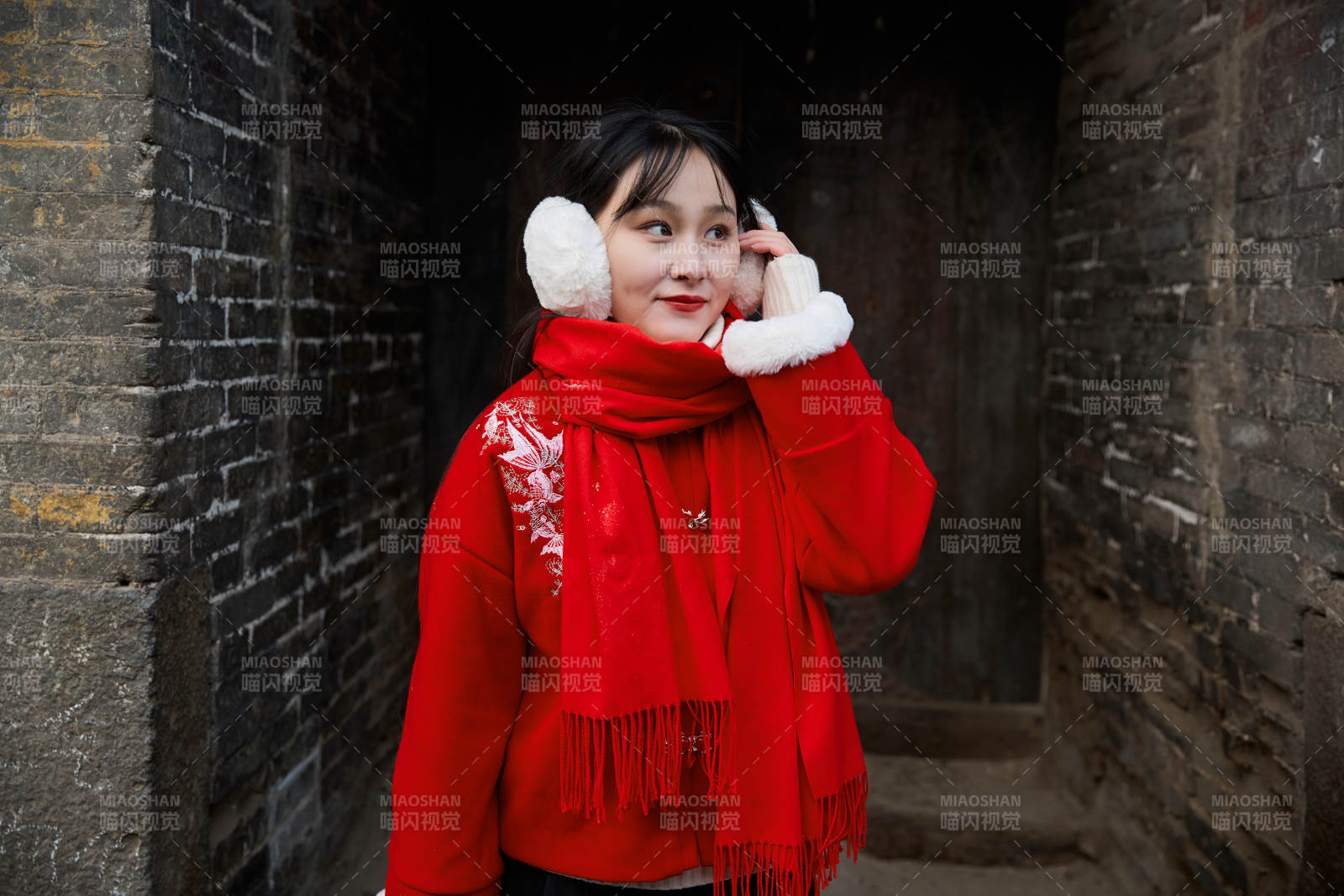 雪后在老城古巷穿着喜庆服饰的亚洲少女图片