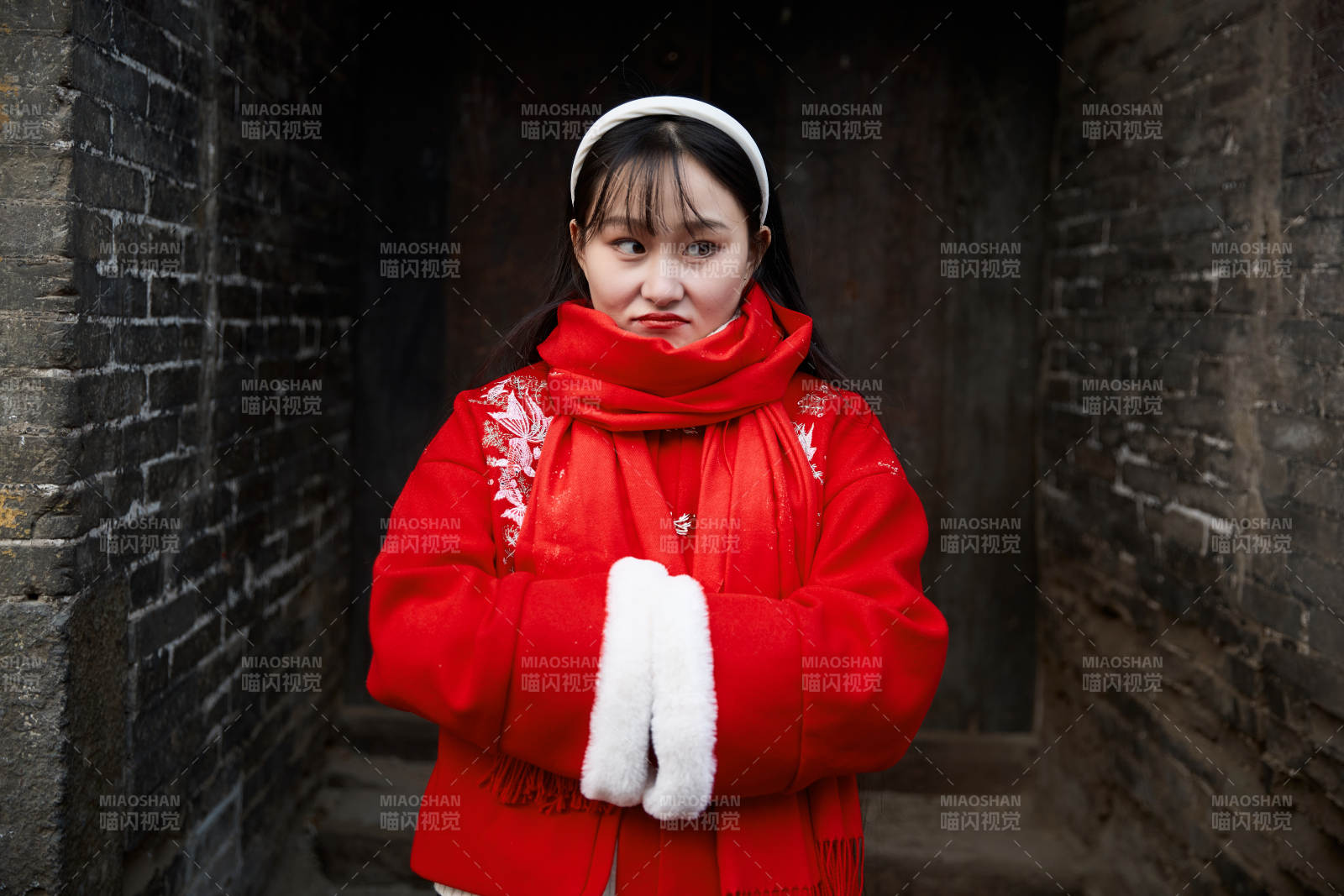 雪后在老城古巷穿着喜庆服饰的亚洲少女图片