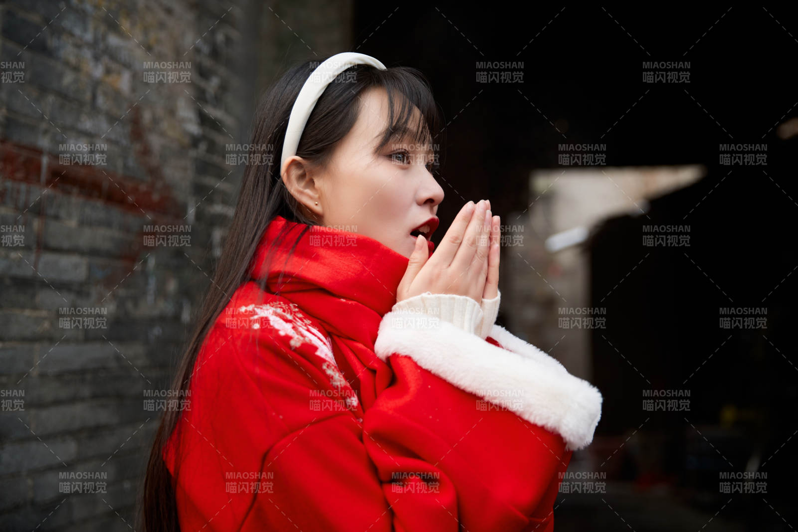 雪后在老城古巷穿着喜庆服饰的亚洲少女图片