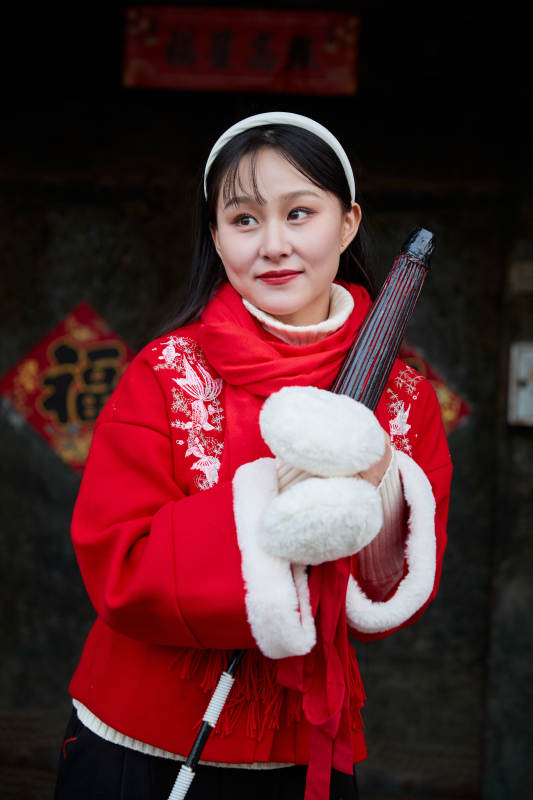 雪后在老城古巷穿着喜庆服饰的亚洲少女图片