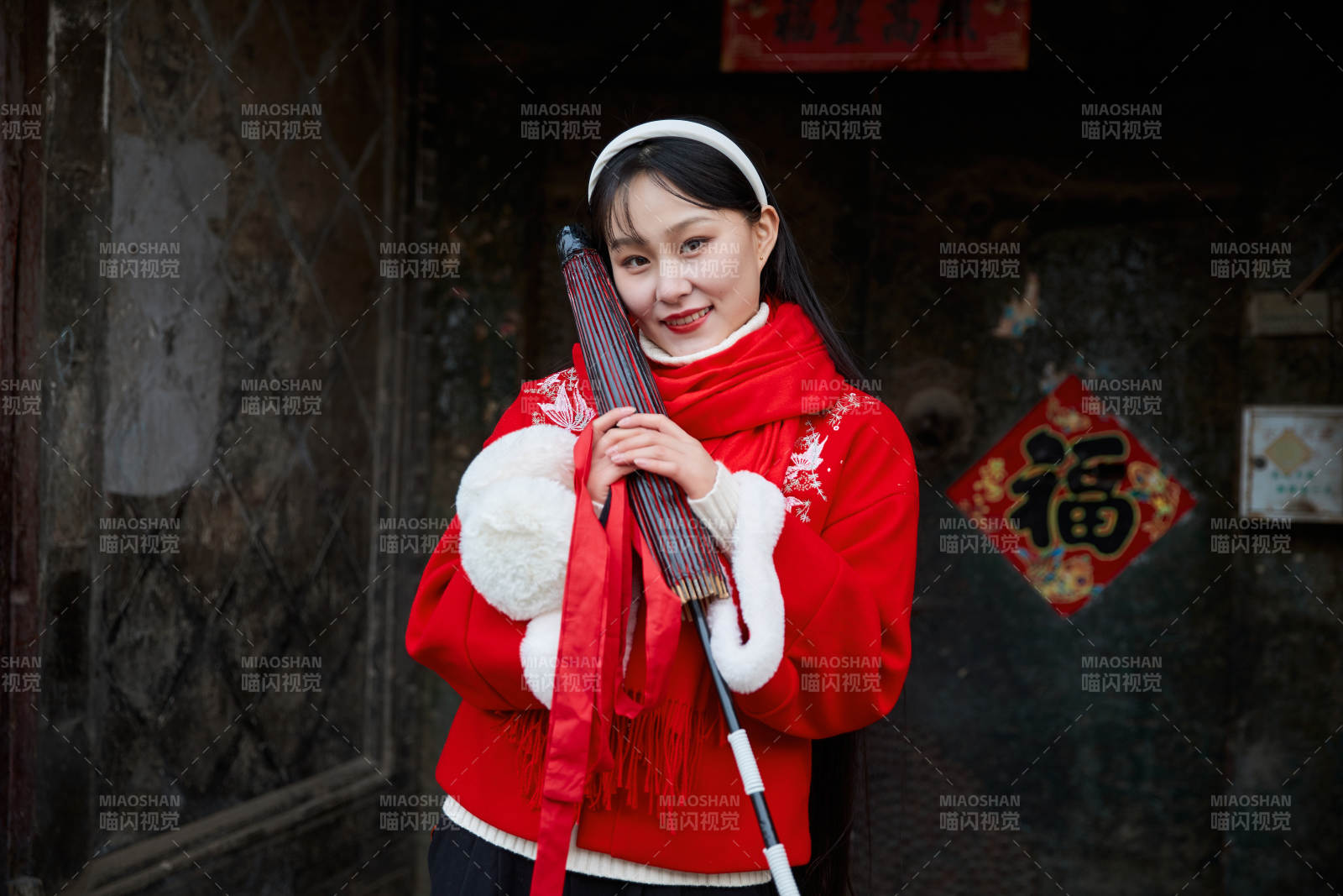 雪后在老城古巷穿着喜庆服饰的亚洲少女图片