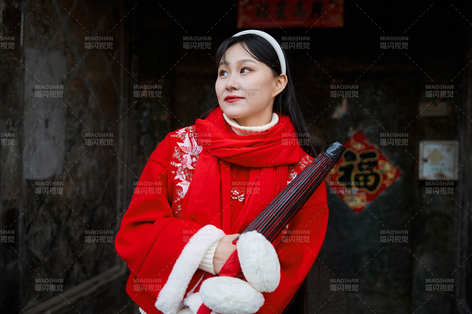 雪后在老城古巷穿着喜庆服饰的亚洲少女图片