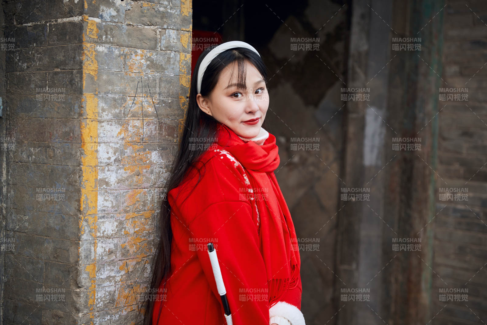 雪后在老城古巷穿着喜庆服饰的亚洲少女图片